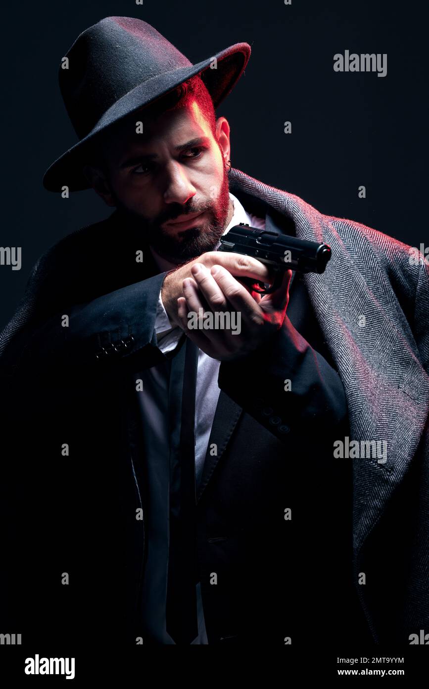 Bodyguard, suit or shooting gun on studio background in dark secret spy, isolated mafia leadership or crime lord security. Model, man and gangster Stock Photo