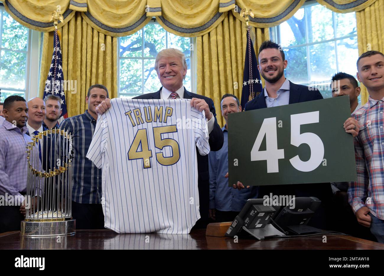 President Donald Trump holds up a Chicago Cubs jersey and Cubs
