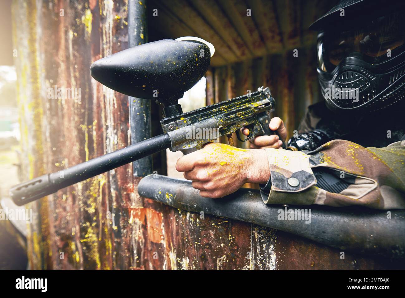 Paintball, gun and target with a sports man playing a military game for