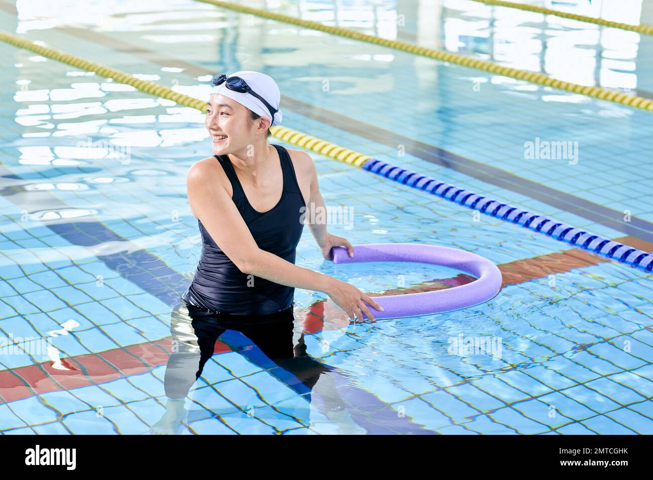 Japanese woman at indoor swimming pool Stock Photo
