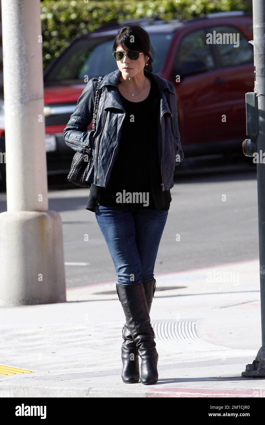 Clutching her leather jacket around her baby bump Selma Blair gives a