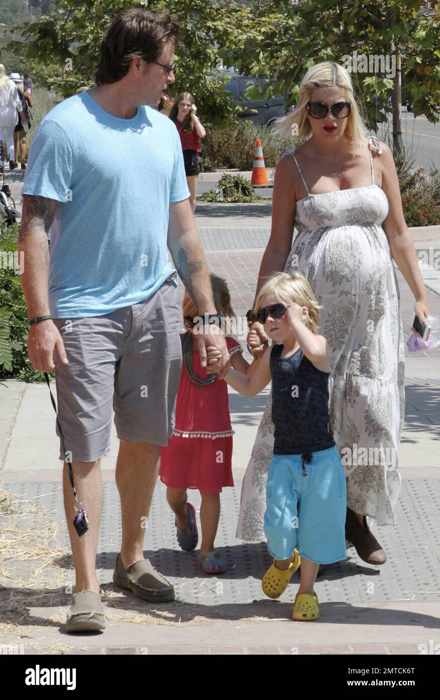 A heavily pregnant Tori Spelling in a long lose fitting white dress and(02)