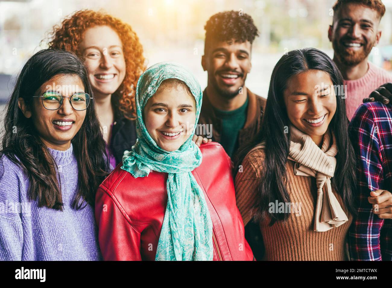 Young diverse people having fun outdoor laughing together - Focus on arabian girl face Stock Photo