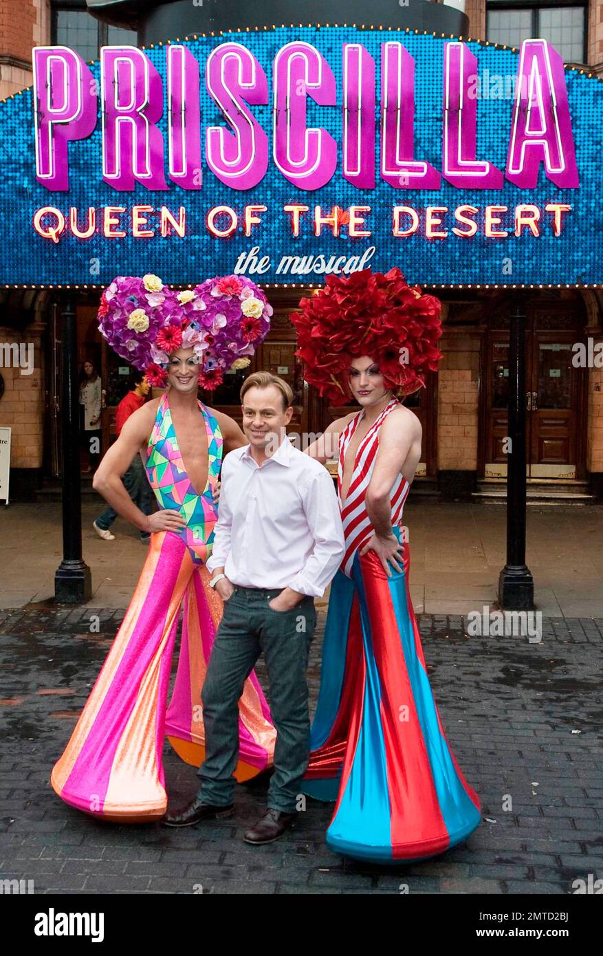 jason-donovan-poses-with-flamboyantly-costumed-cast-members-of