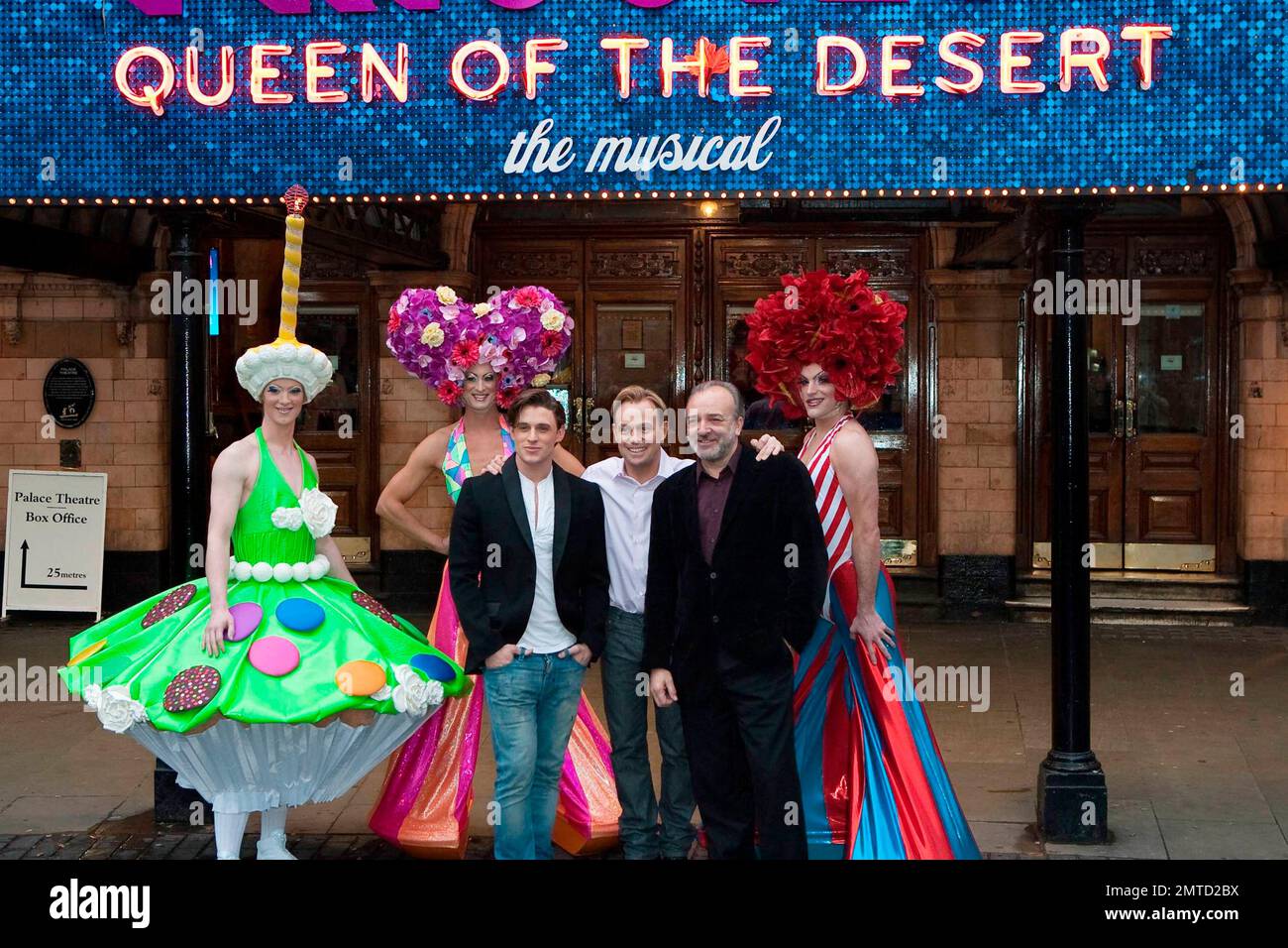 (LR) Oliver Thornton, Jason Donovan and John Bowe pose with flamboyantly costumed cast members