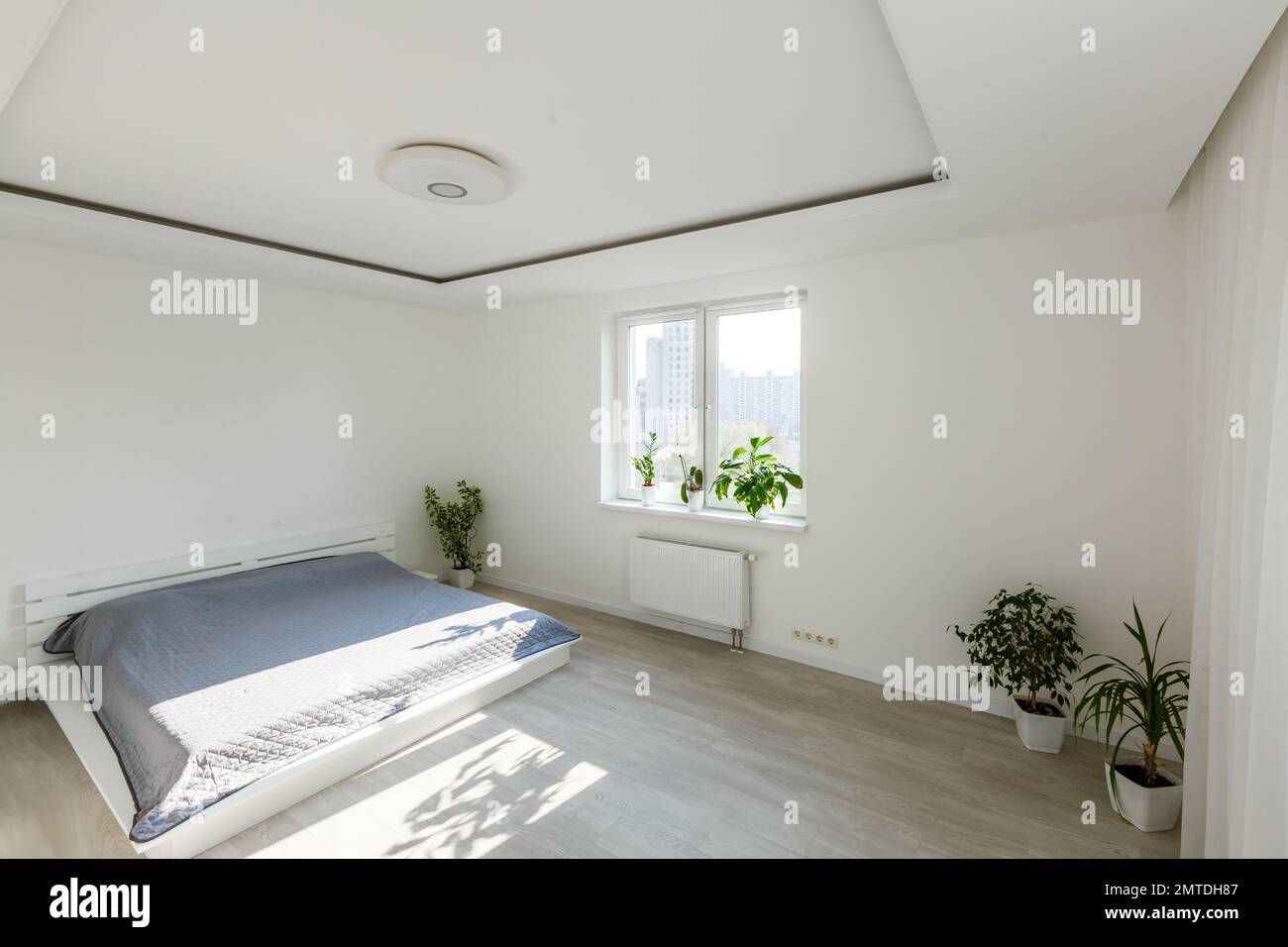 White bedroom with brick elements, balcony, double bed, desk Stock Photo