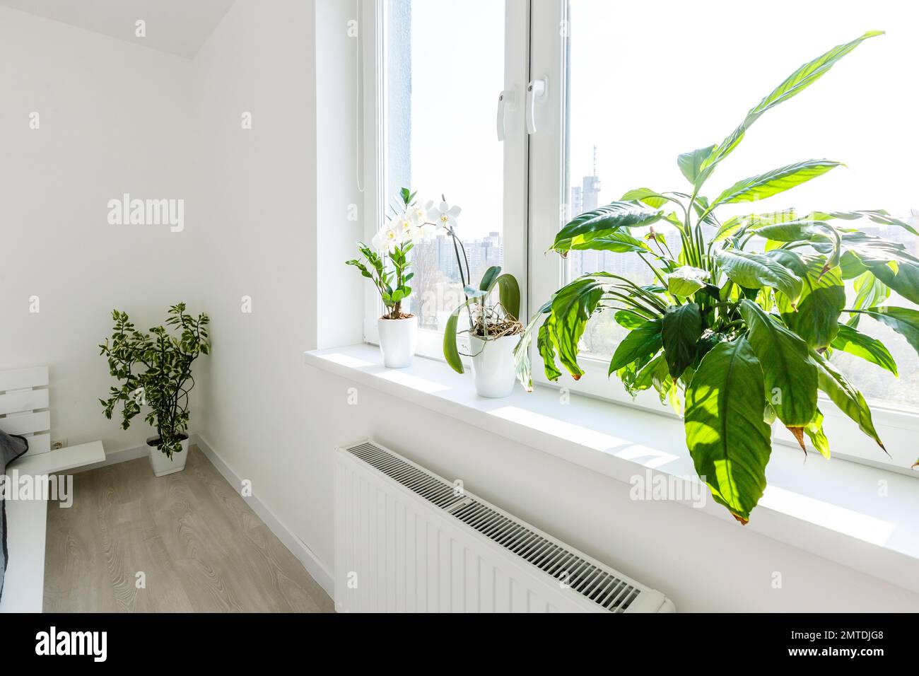 White bedroom with brick elements, balcony, double bed, Stock Photo