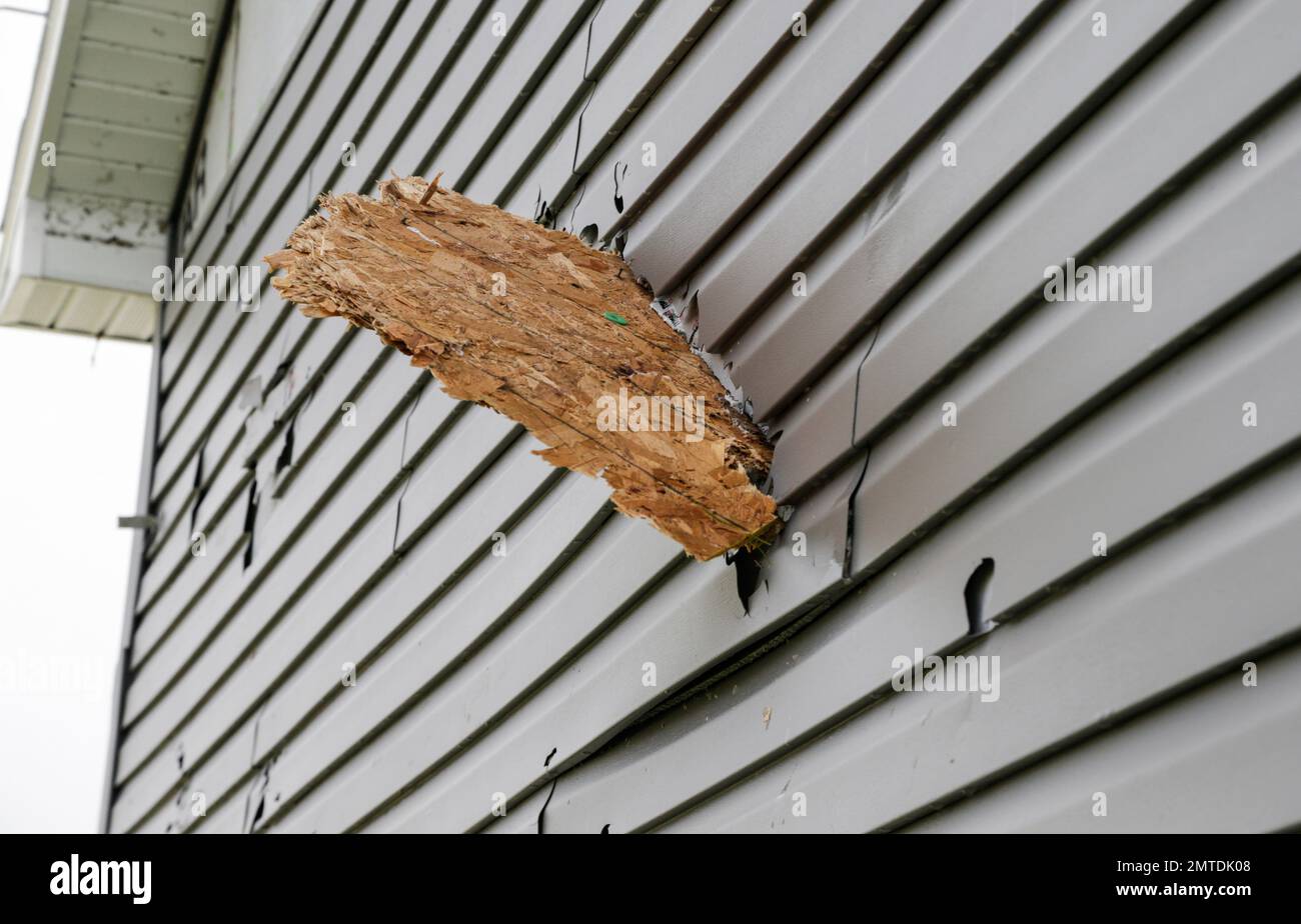 A plywood board impales the siding of a weather damaged home in the Hyda Hills neighborhood in