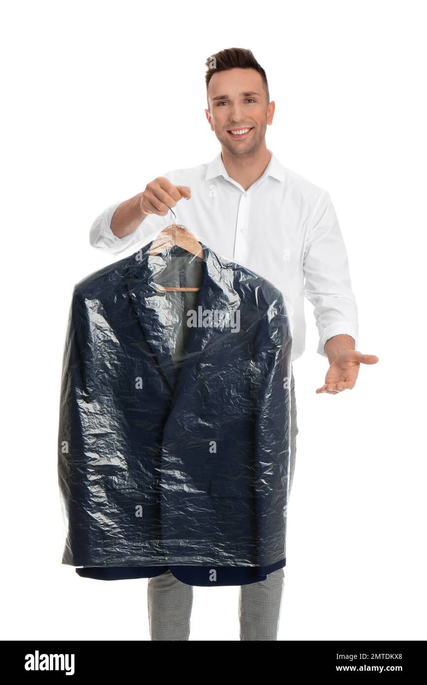 Man holding hanger with jacket in plastic bag on white background. Dry ...