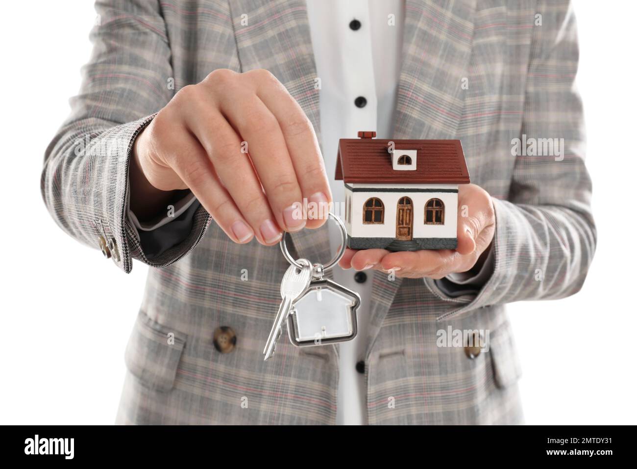 Real estate agent holding house model and key on white background ...