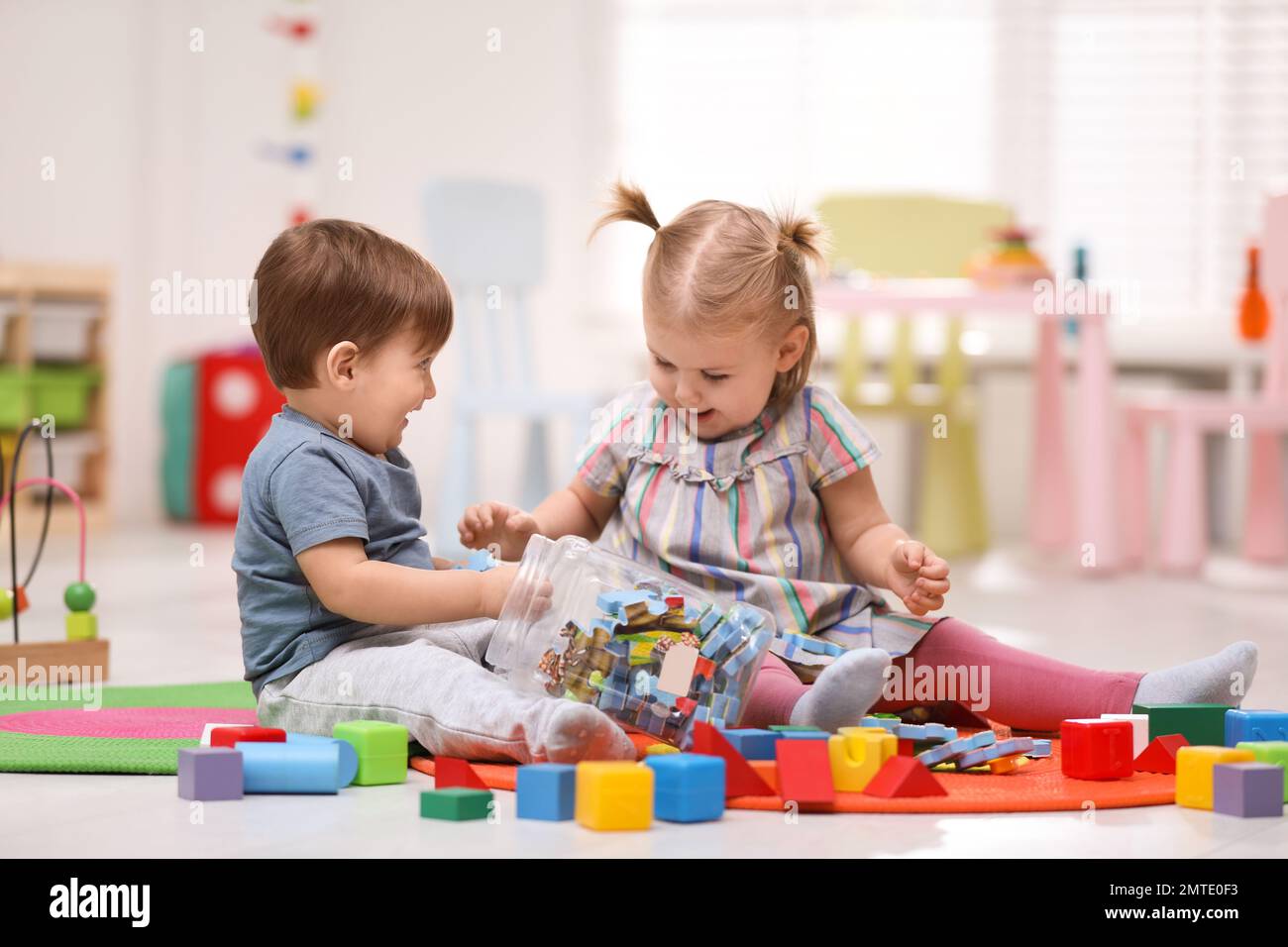 Cute little children playing together on floor at home Stock Photo - Alamy