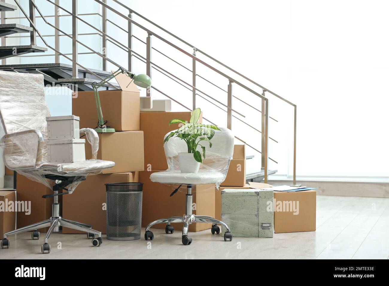 Moving boxes and stuff near stairs in room Stock Photo Alamy