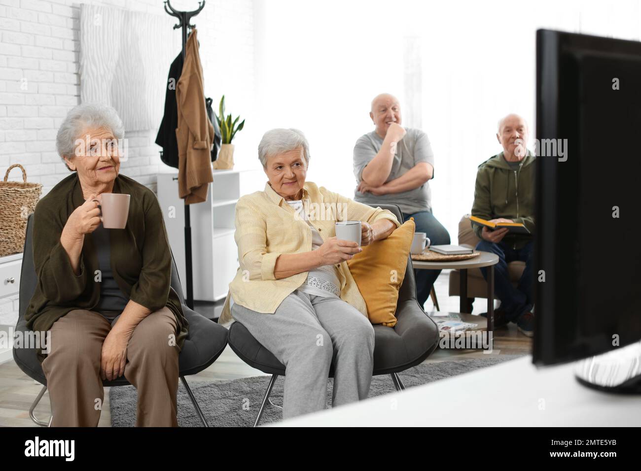 Elderly people watching TV in geriatric hospice. Senior people care