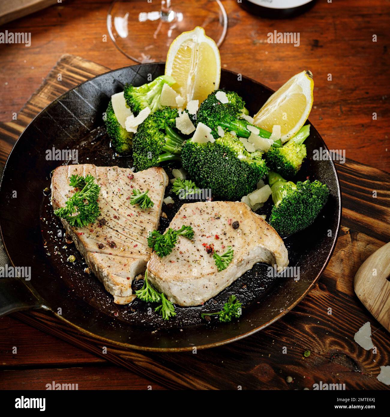 Schweinesteak / Brokkoli / Broccoli mit Zitrone und Petersilie in der Pfanne Stock Photo