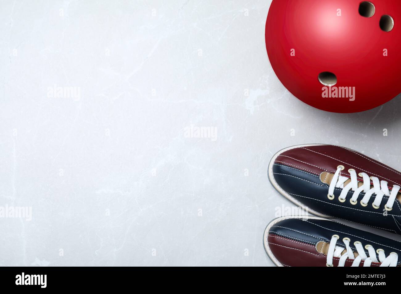 Bowling ball and shoes on light grey marble background, flat lay. Space for text Stock Photo
