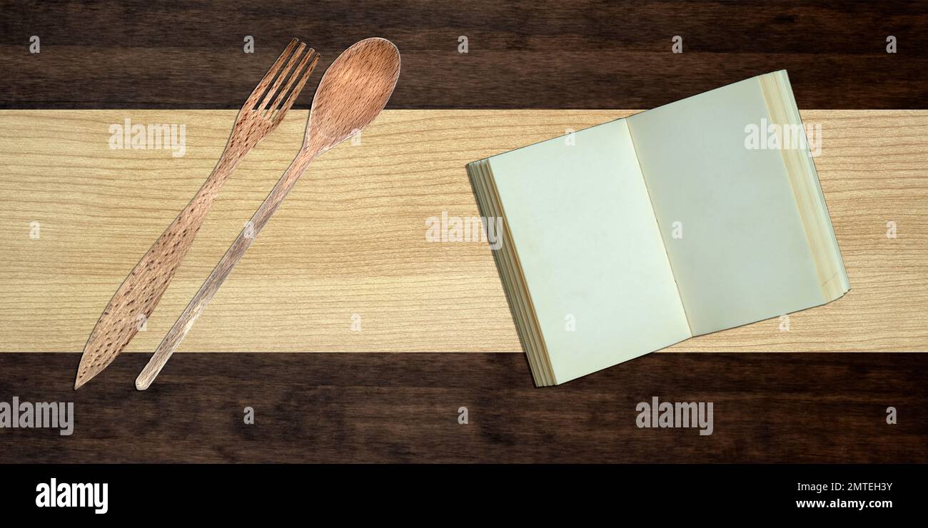 Utensils and vintage cooking book on wooden table hires stock