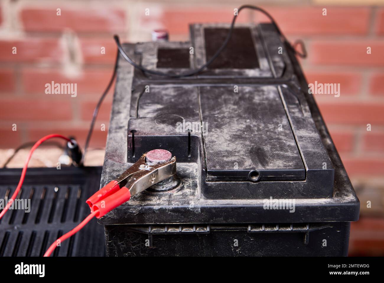 Car battery is connected to charger with alligator clips Stock Photo