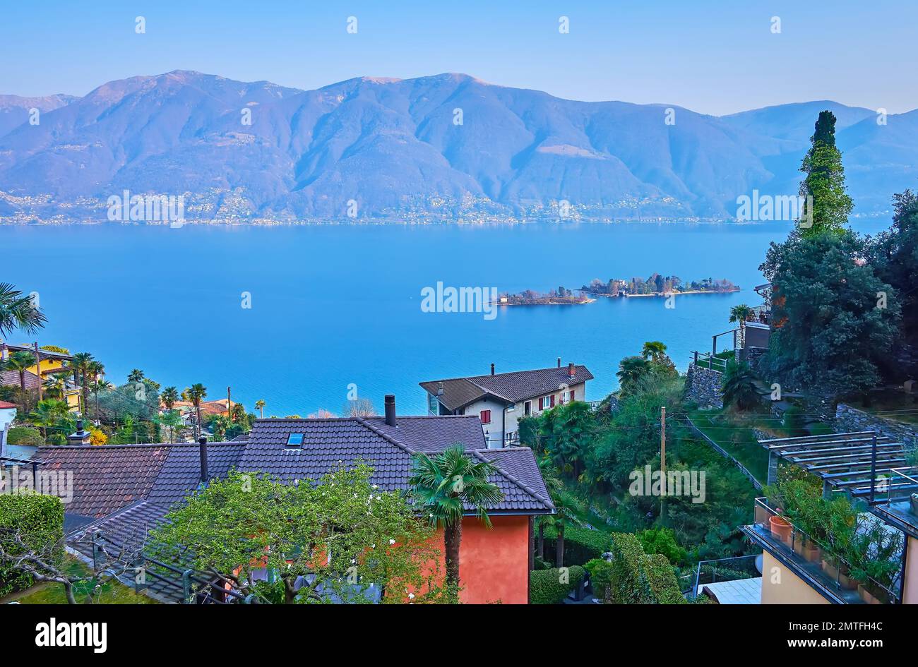 Enjoy Alpine scenery, hazy Lake Maggiore and tiny Brissago Islands, seen from the garden in Ronco sopra Ascona, Switzerland Stock Photo