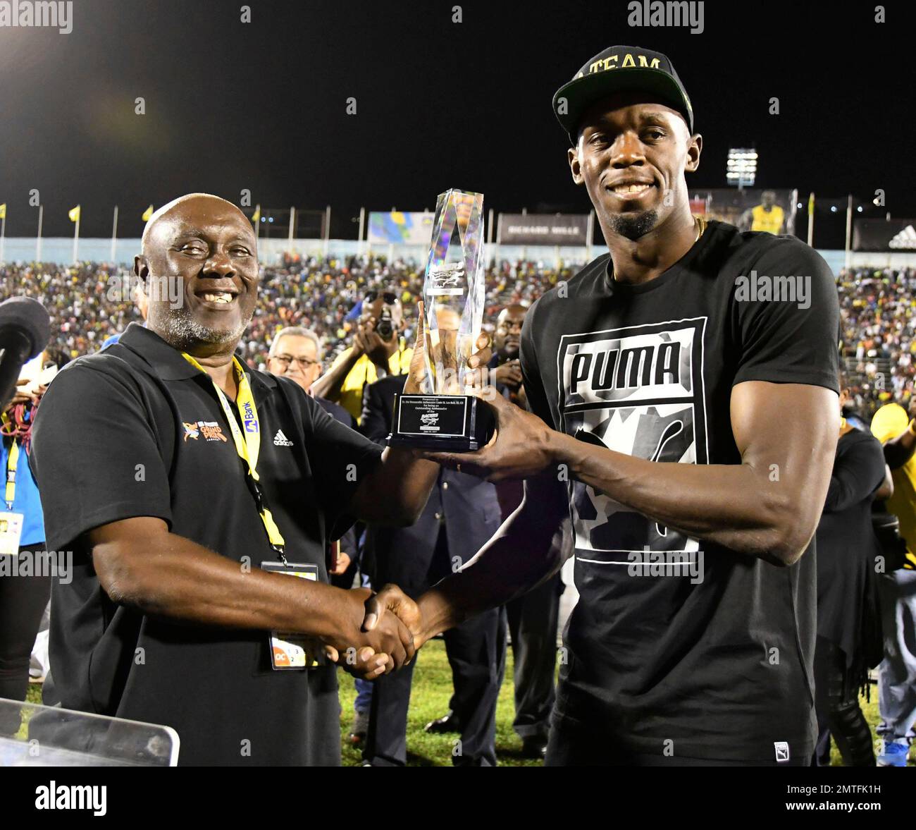 Jamaica's Usain Bolt receives a special award from his coach, Glen
