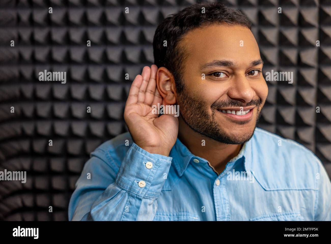 Smiling young man having a hearing checkup and looking contented Stock Photo