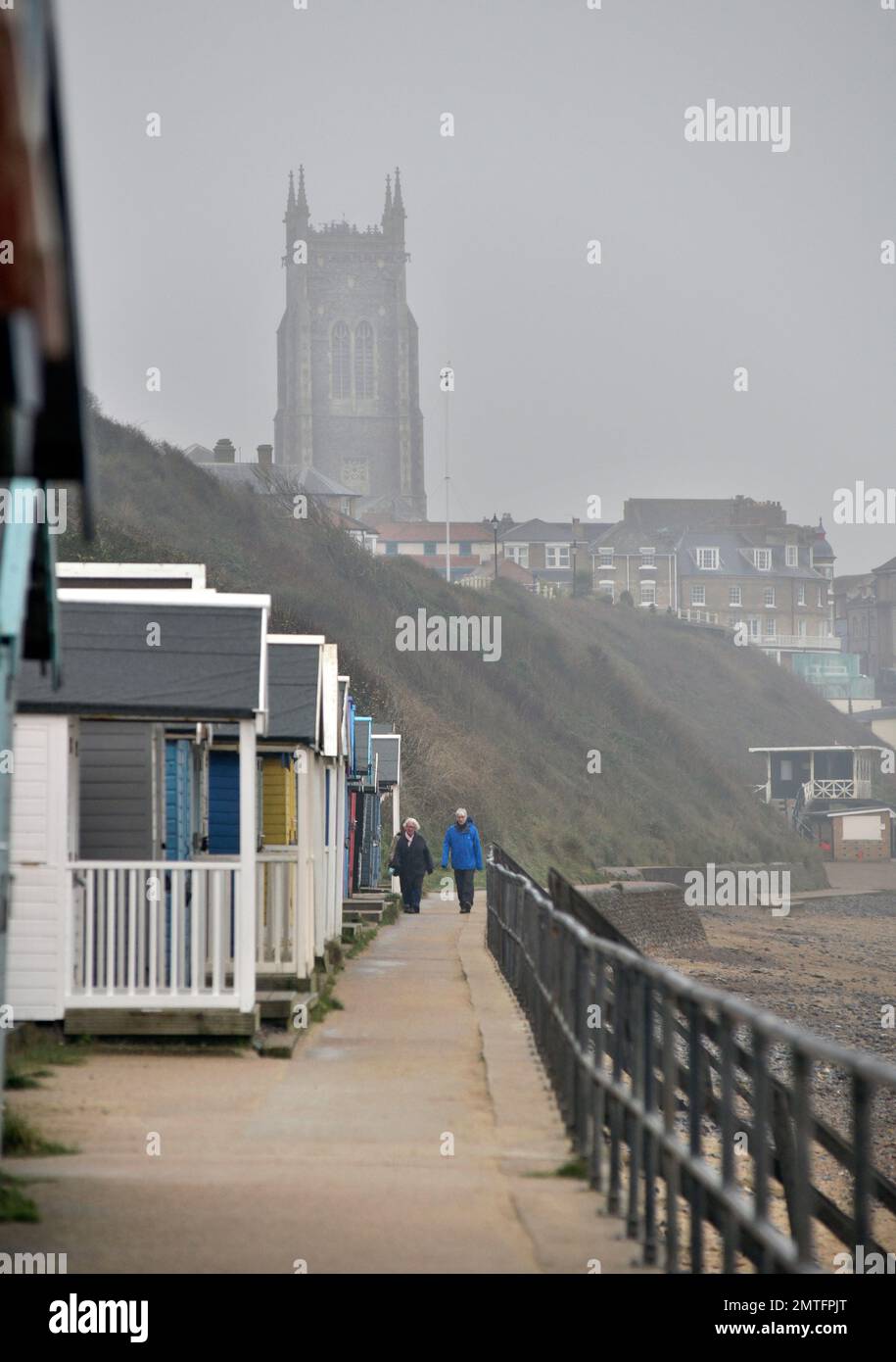 misty dull day with older couple walking on cromer promenade, cromer north norfolk england Stock Photo