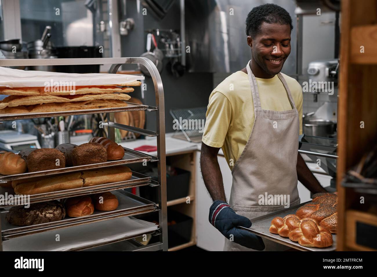 Smiling man enjoying working in bakery Stock Photo