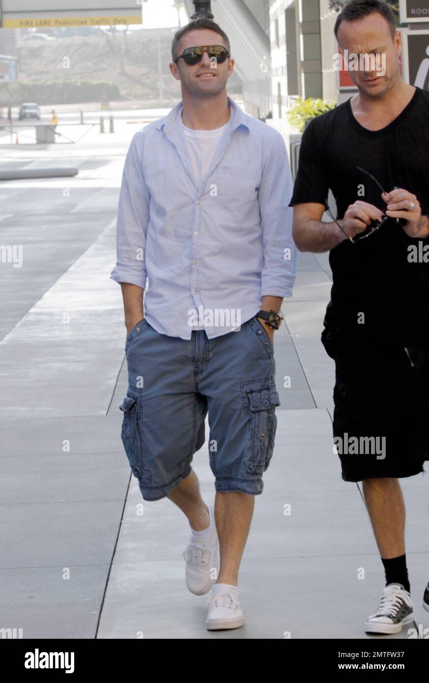 EXCLUSIVE!! The newest addition to the LA Galaxy soccer team, Irish footballer Robbie Keane poses with a billboard welcoming him to LA while out and about with a friend. Earlier in the day, Keane took part in his first practice with the team and attended a press conference with David Beckham to discuss his addition to the team. Los Angeles, CA. 19th August 2011. Stock Photo