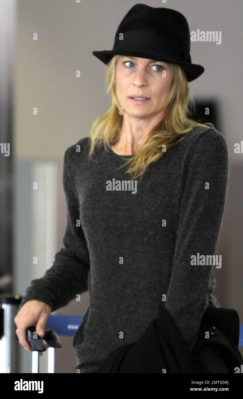 EXCLUSIVE!! Six months after her divorce from Oscar winning actor Sean Penn, actress Robin Wright, 44, makes her way through LAX with her son Hopper Penn, 18.  Despite not wearing makeup Wright's skin looked fresh and wrinkle free.  According to reports Robin received half of her ex's earnings in their divorce settlement, the news came after Sean reportedly mentioned that he 'had just got taken for one half of everything I had in the divorce' when speaking about his social work in Haiti. Los Angeles, CA. 01/08/11. Stock Photo