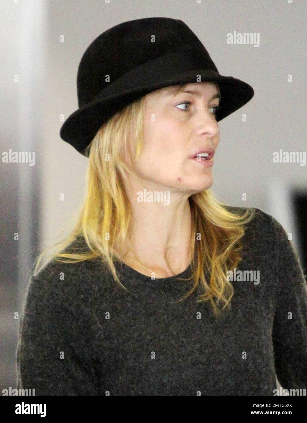 EXCLUSIVE!! Six months after her divorce from Oscar winning actor Sean Penn, actress Robin Wright, 44, makes her way through LAX with her son Hopper Penn, 18.  Despite not wearing makeup Wright's skin looked fresh and wrinkle free.  According to reports Robin received half of her ex's earnings in their divorce settlement, the news came after Sean reportedly mentioned that he 'had just got taken for one half of everything I had in the divorce' when speaking about his social work in Haiti. Los Angeles, CA. 01/08/11. Stock Photo