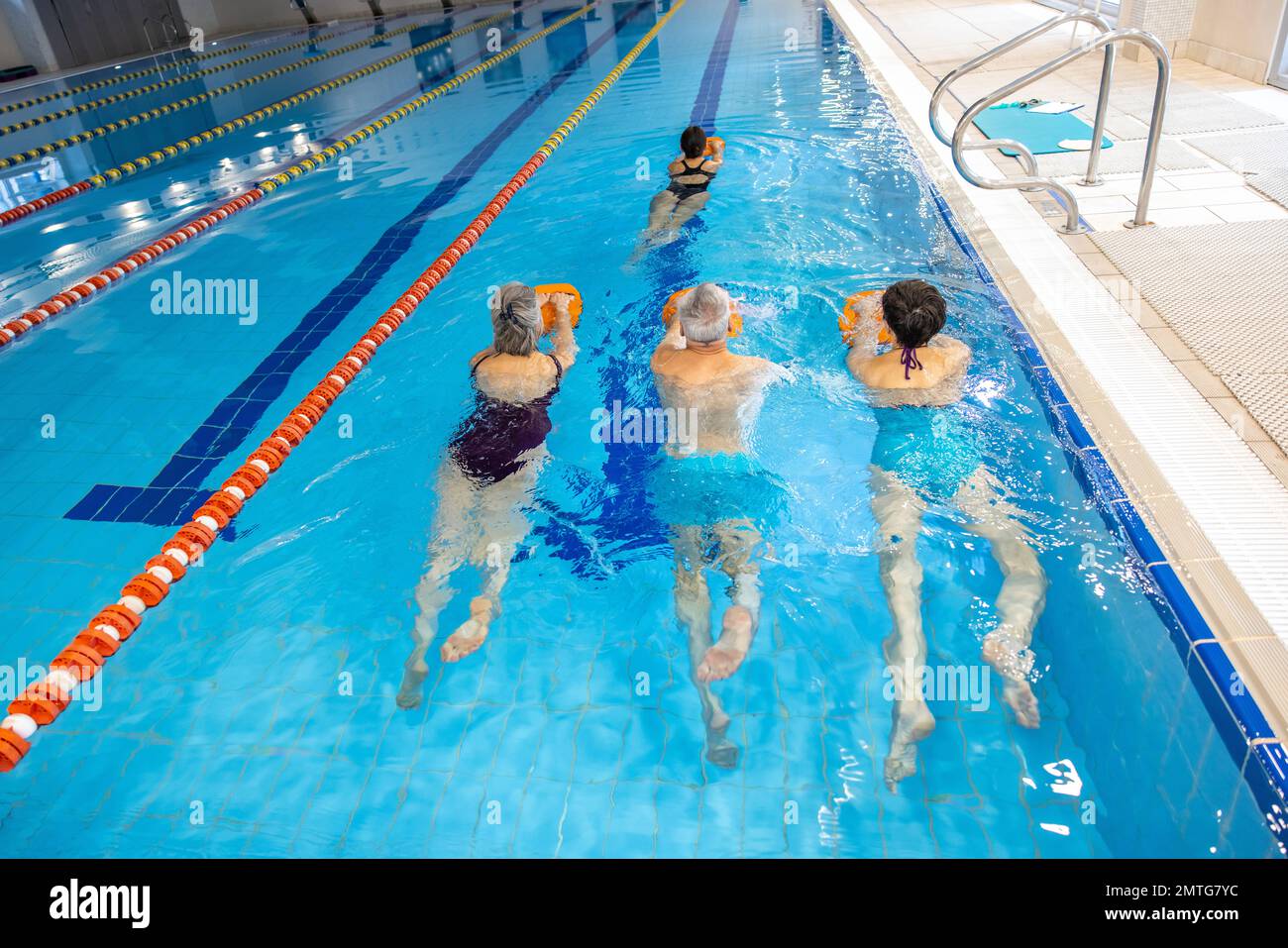 Group of people swimming together in the swimming pool Stock Photo