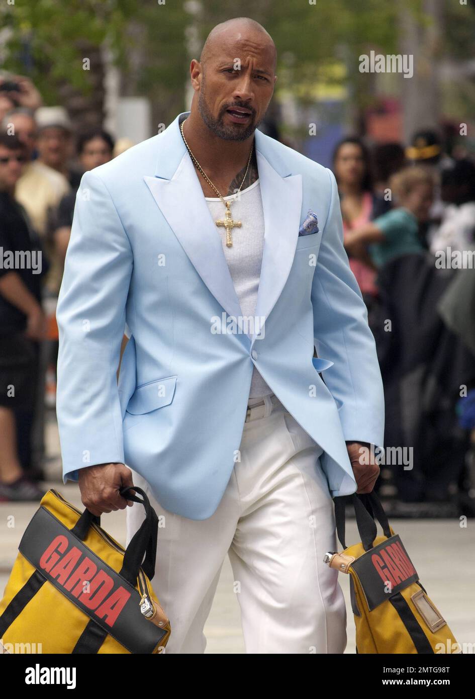 Wearing a baby blue colored jacket, white shirt, white pants, white shoes  and a crucifix necklace, Dwayne 'The Rock' Johnson is seen on set shooting  scenes for his up coming new film "