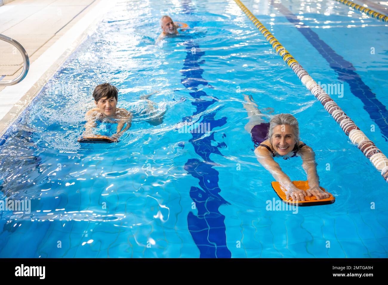 Group of people swimming in the swimming pool and looking enjoyed Stock Photo