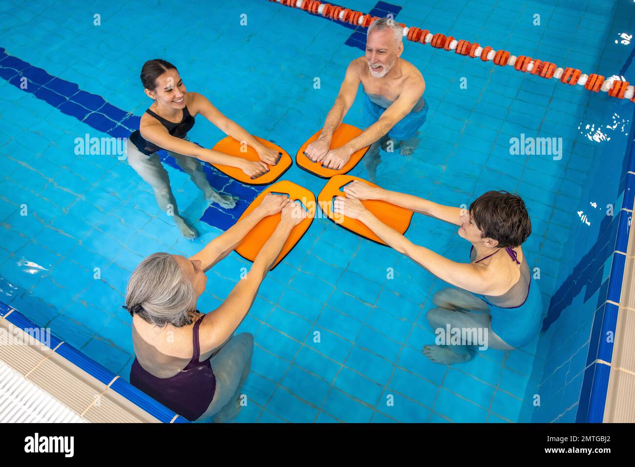 Group of seniors having a swimming class at the swimming pool Stock Photo