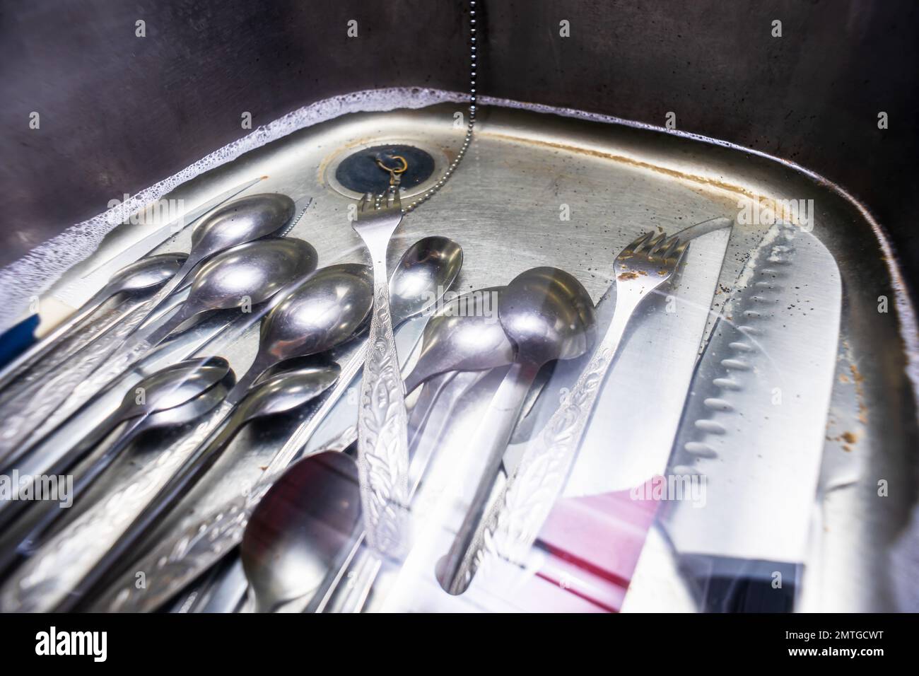 Dirty dishes in a kitchen sink filed with a water - wide angle Stock Photo