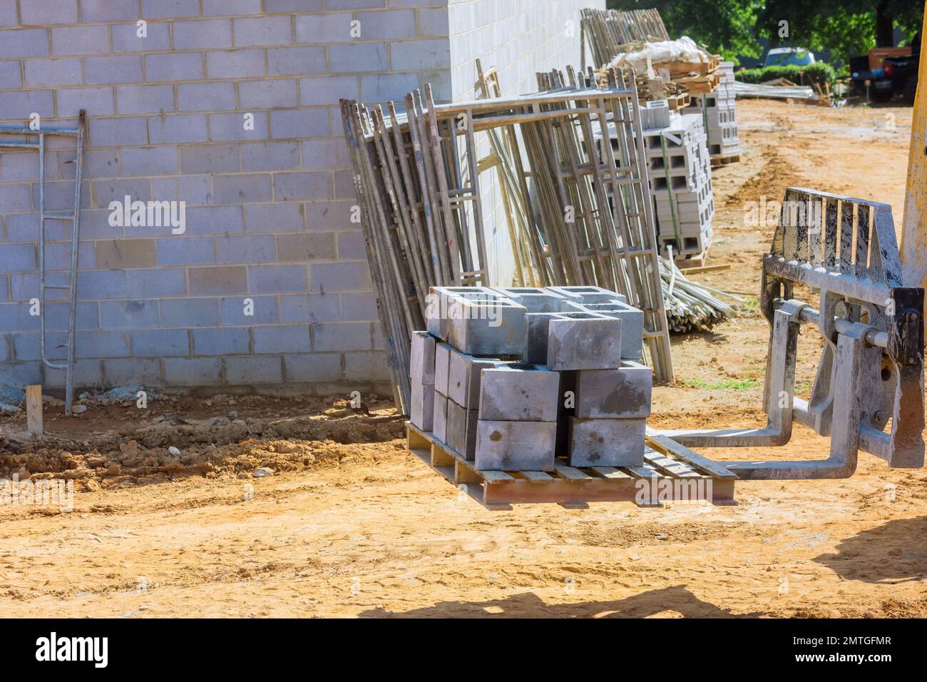 Boom truck forklift moving cement blocks to place where wall of house is going to be installed Stock Photo