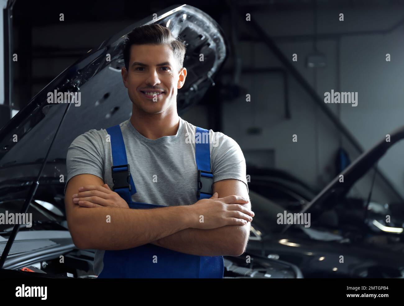 Mechanic near automobile in service center. Modern car diagnostic Stock