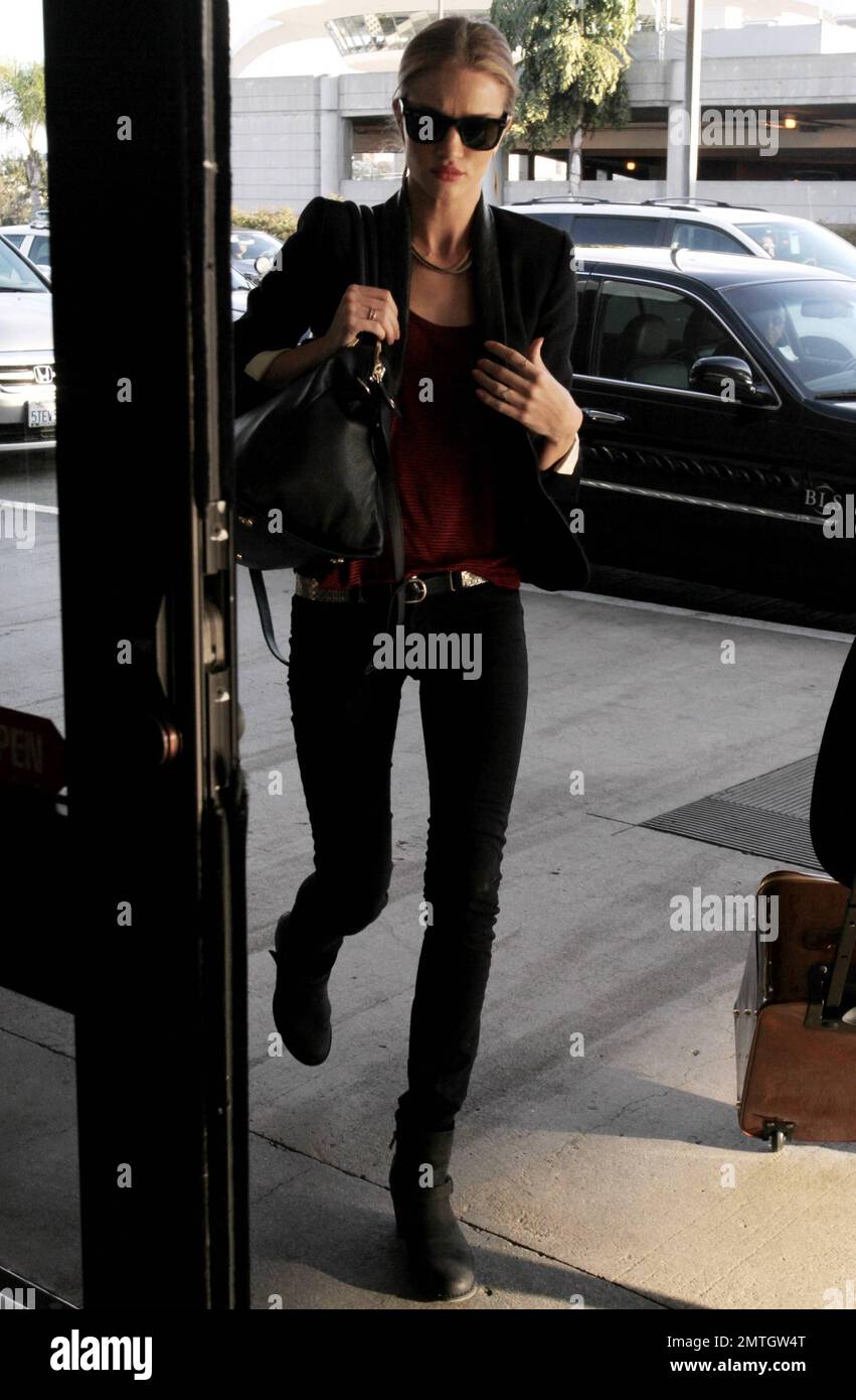 UK model and actress Rosie Huntington-Whiteley looks lovely in black jeans,  a red top and black jacket as she arrives at Los Angeles International  Airport. Los Angeles, CA. 12th February 2012 Stock