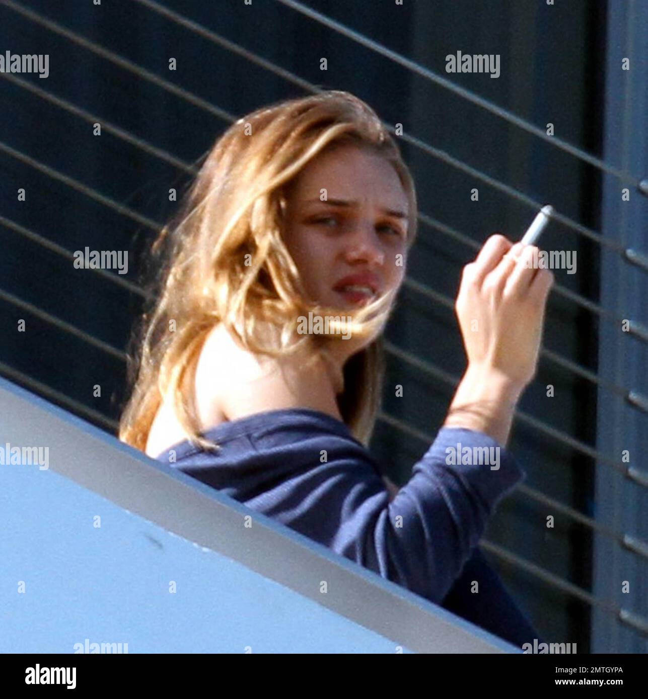 Rosie Huntington-Whiteley chats with pals and smokes a cigarette outside  her hotel in South Beach. The model is in town with her beau, Jason  Statham, to celebrate the new years at a