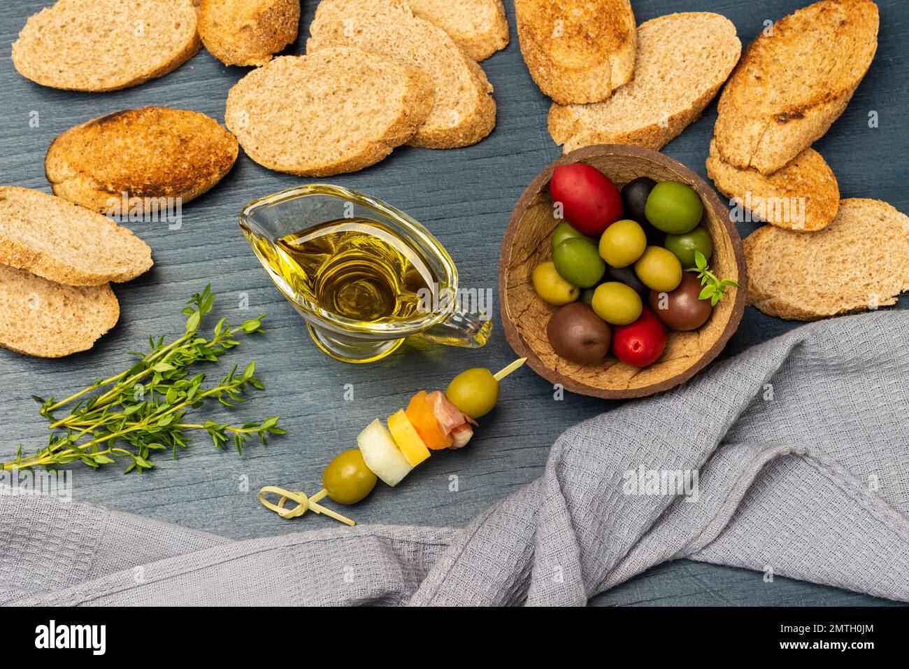 Toasted bread. Gray napkin. Olives of different varieties and colors in ...