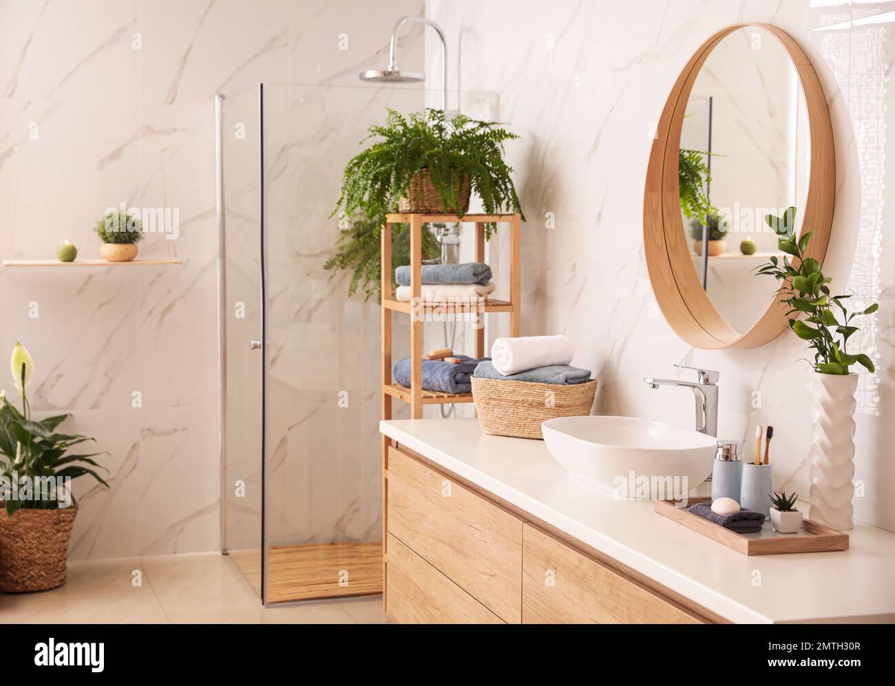 Stylish bathroom interior with countertop, shower stall and houseplants