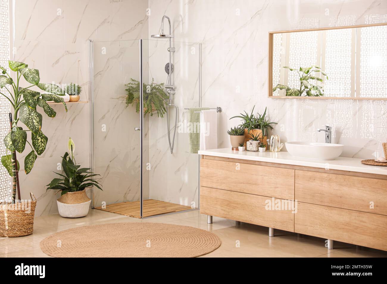 Stylish bathroom interior with countertop, shower stall and houseplants