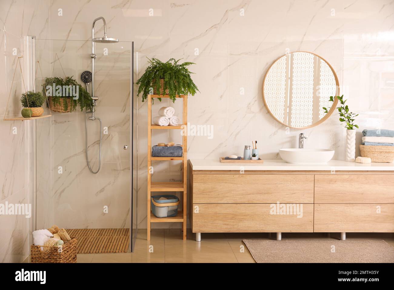 Stylish bathroom interior with countertop, shower stall and houseplants
