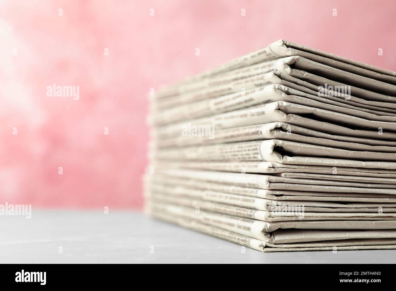 Stack of newspapers on pink background, closeup. Journalist's work Stock Photo