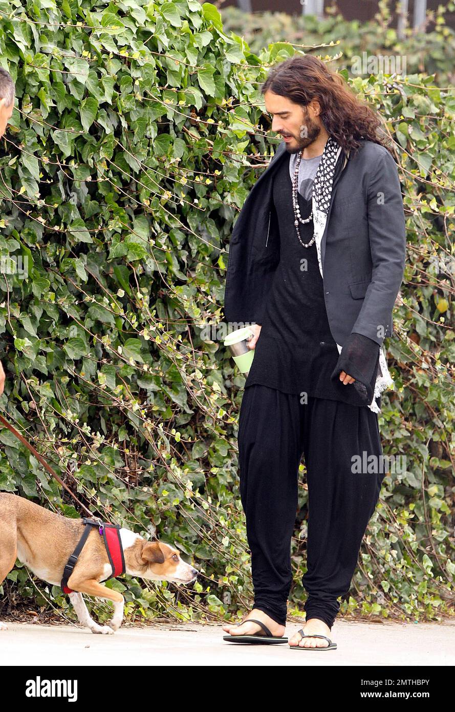 EXCLUSIVE!! Wearing quite the interesting outfit and carrying a travel mug,  actor Russell Brand looks as though he hasn't a care in the world, slowing  down to admire an inquisitive dog while