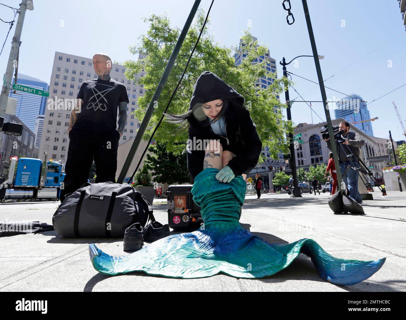 Victoria Lemeow pulls on a mermaid costume before having hooks embedded  into her back and being dangled from the trip above her as a protest  against fishing Monday, June 5, 2017, in