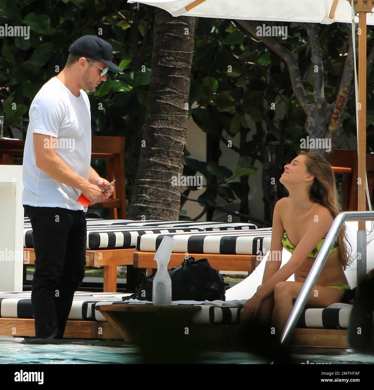 Ryan Phillippe and Paulina Slagter were spotted kissing while they hung out at their pool in South Beach. Ryan appeared to have a meeting booked as he had to leave his bikini beauty behind leaving the hotel with a back pack. Slender Paulina, who showed off a slightly rounded tummy, enjoyed a healthy lunch before cooling off in the pool in her yellow bikini. Miami Beach, FL. 11th June 2014. Stock Photo