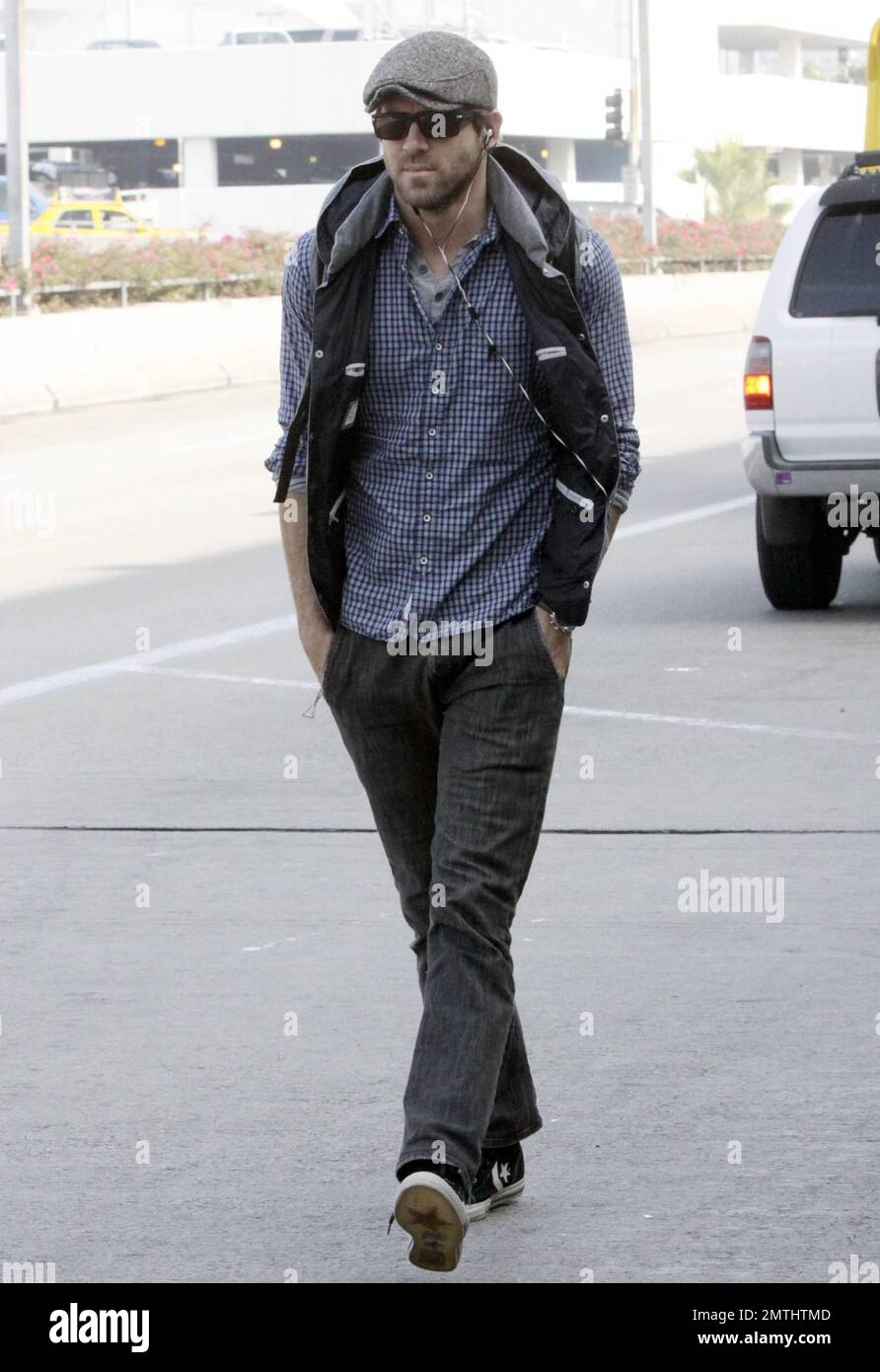 Actor Ryan Reynolds looks casual in a plaid shirt grey hat and