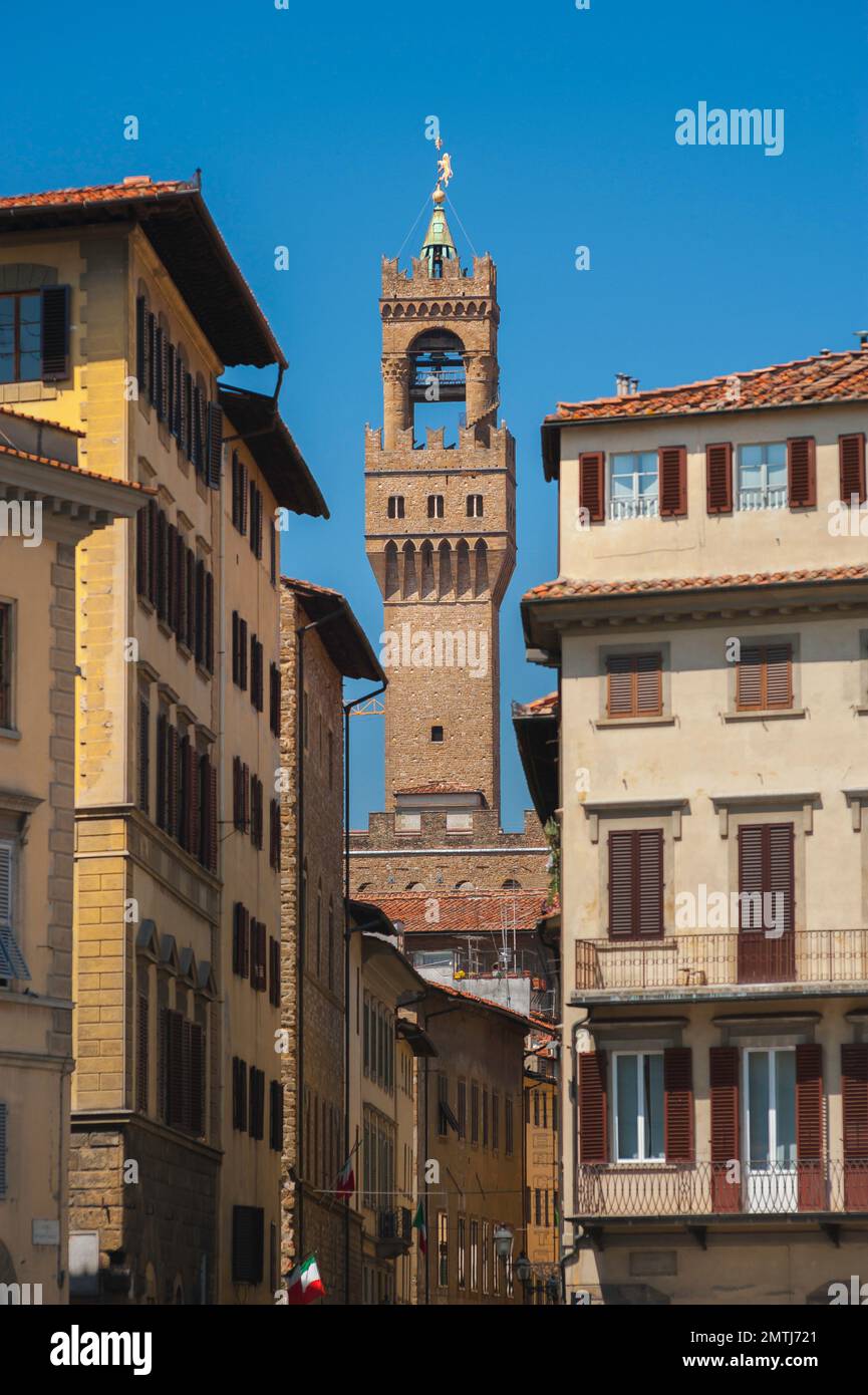 Florence street, view in summer of the Torre di Arnolfo, a landmark tower rising from the Palazzo Vecchio in the centre of the city of Florence, Italy Stock Photo
