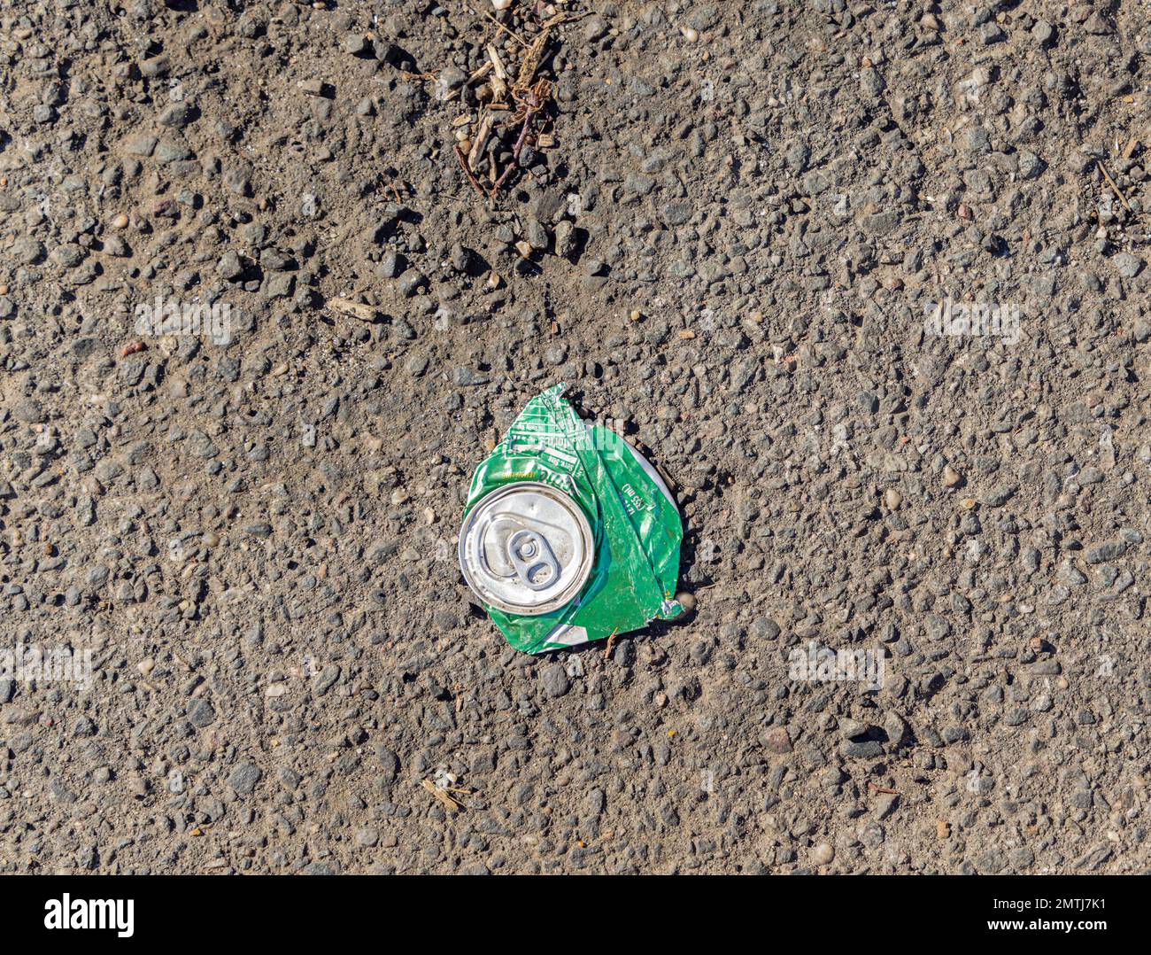 a flattened can of Sprite on a asphalt road Stock Photo