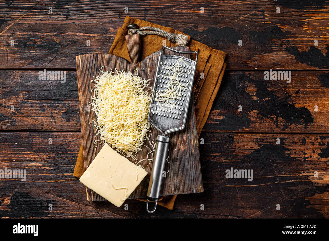 https://c8.alamy.com/comp/2MTJA3D/piece-of-semi-hard-cheese-and-grated-cheese-with-grater-wooden-background-top-view-2MTJA3D.jpg